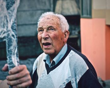 Portrait of man holding camera outdoors