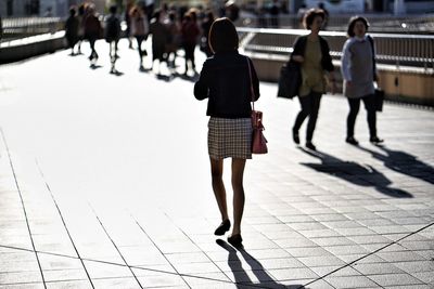 Rear view of women walking on zebra crossing