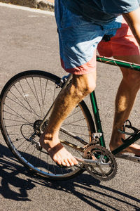 Low section of man riding bicycle on street