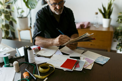 Male costume designer working at table in studio