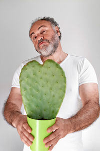 Midsection of man holding apple against white background