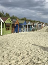 Row of houses on beach against sky