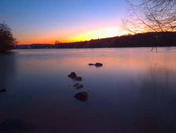 Scenic view of lake against sky at sunset