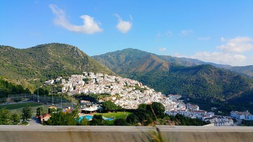 High angle view of town by mountains against sky