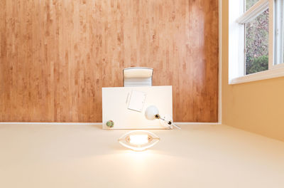 Electric lamp on table against wall at home