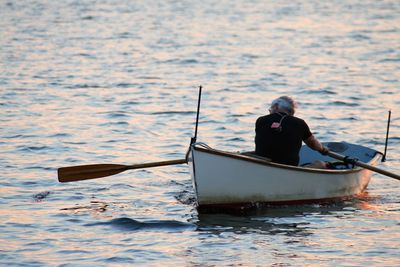 Rear view of man in boat sailing in sea