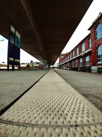Surface level of empty footpath amidst buildings in city