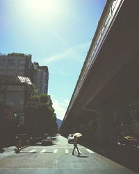 Rear view of woman walking on road in city