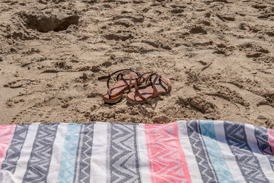 High angle view of shoes on sand at beach