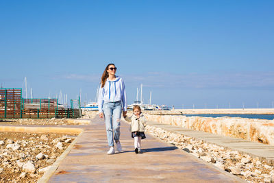 Woman on beach by sea against clear sky