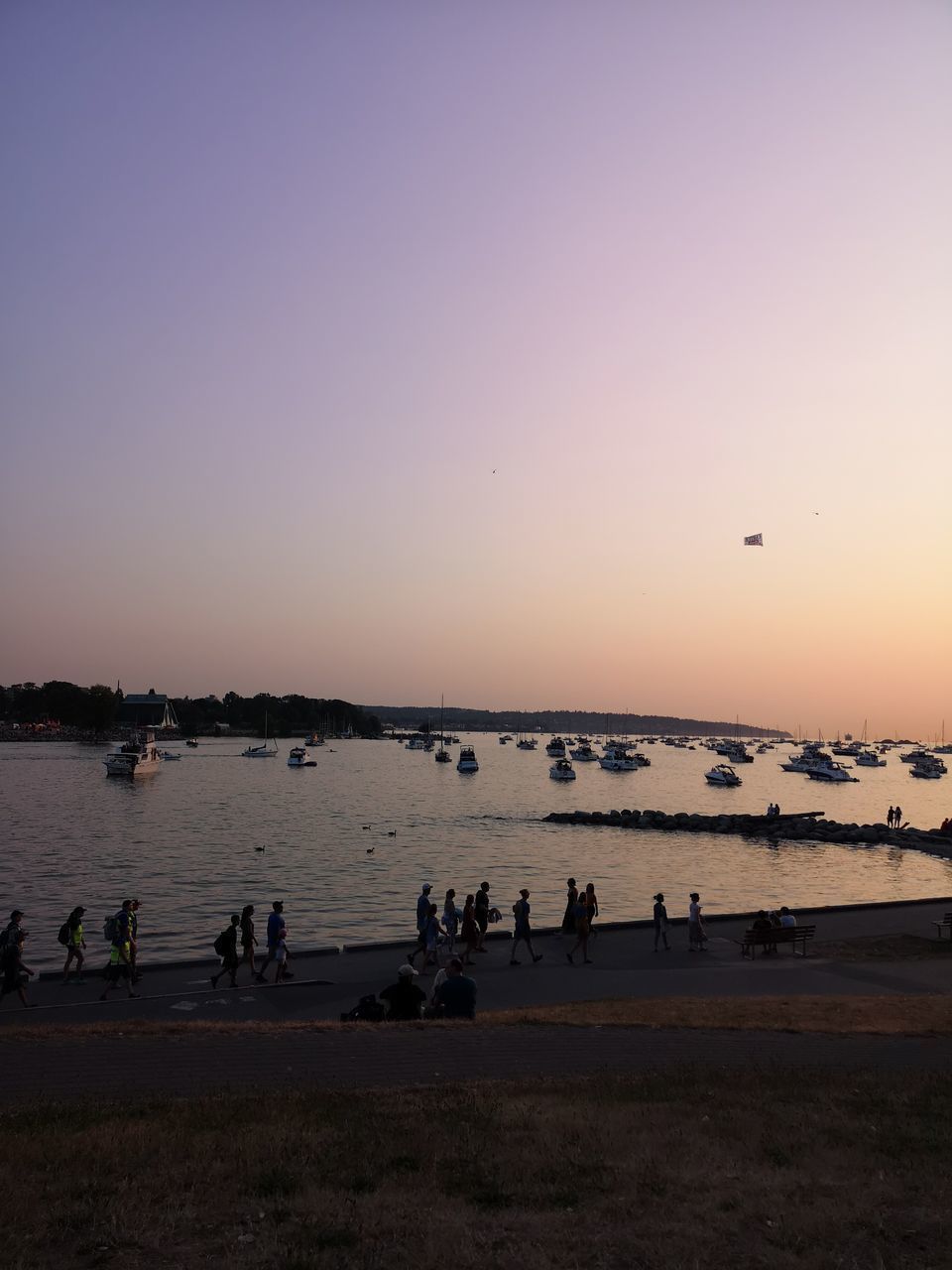 GROUP OF SILHOUETTE PEOPLE ON BEACH AGAINST CLEAR SKY