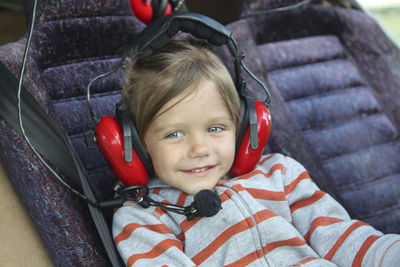 Close-up of cute girl wearing headphones sitting in air vehicle