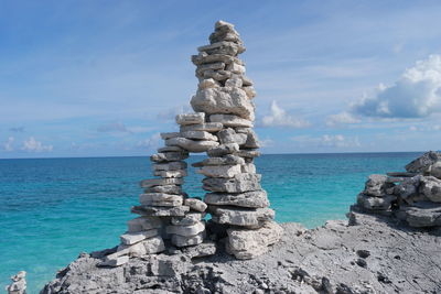 Stack of rocks on shore against sky