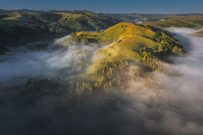 View from drone of incredible atmosphere with foggy hills at sunrise. 