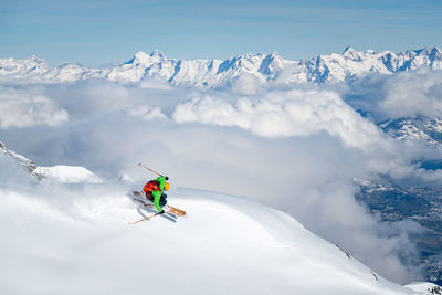 People skiing on snowcapped mountain against sky