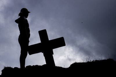 Low angle view of silhouette man standing on field against sky