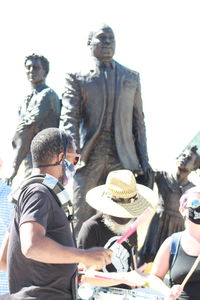 People sitting by statue