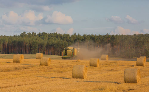 Hay bales on field against sky