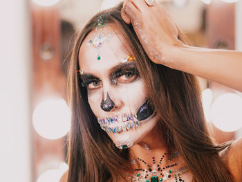 Close-up portrait of young woman with spooky face paint