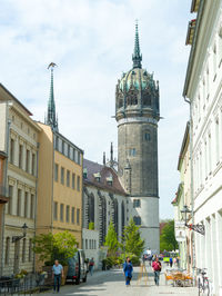 People in front of historical building against sky