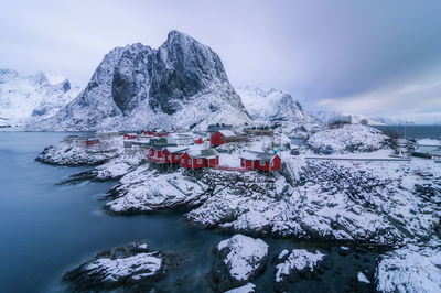 Traditional building by snowcapped mountains against sky