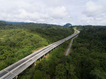 High angle view of road amidst trees against sky