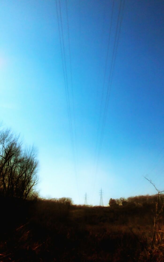 VIEW OF FIELD AGAINST CLEAR BLUE SKY