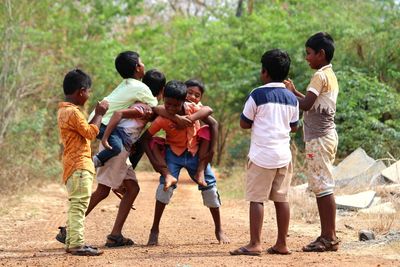 Rear view of people standing on land