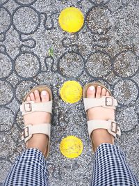 Low section of person standing on patterned footpath