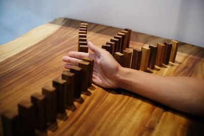 Close-up of cropped hand playing domino on table