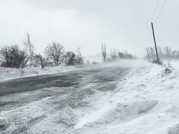 Scenic view of snow covered land against sky