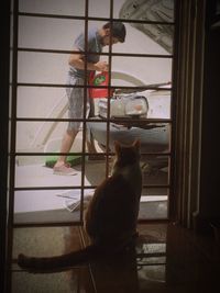 Low section of man with dog sitting at window