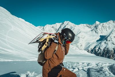 Man skiing on snowcapped mountain against sky