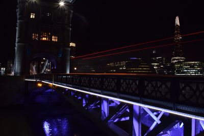 Illuminated suspension bridge in city at night