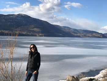 Young woman standing by frozen lake