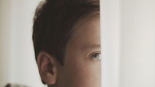 Close-up portrait of young boy peeking