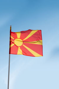 Low angle view of flag against blue sky