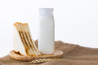 Close-up of bread on table against white background