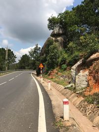 Road amidst trees against sky