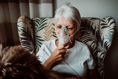 Portrait of man drinking on sofa at home