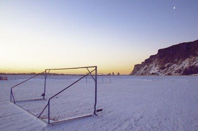 Scenic view of snow covered land against clear sky during sunset