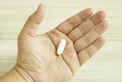 Cropped image of hand holding capsule