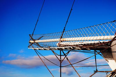 Low angle view of cranes against blue sky