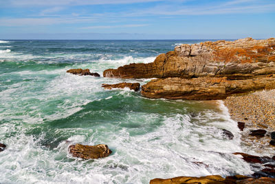 Rocks on sea shore against sky