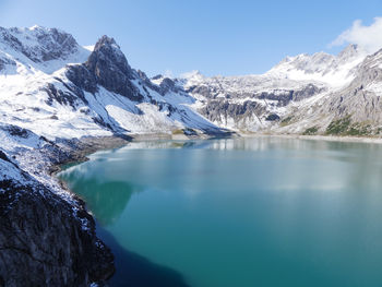 Scenic view of lake and snowcapped mountains against sky