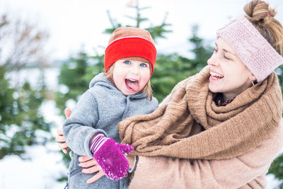 Portrait of young mother and cute child having fun together in the winter