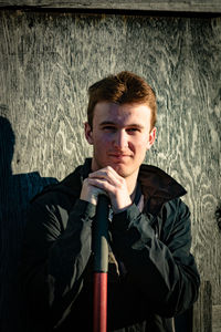 Portrait of young man standing against wall
