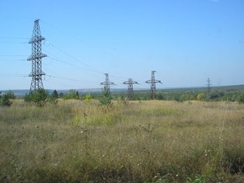 Electricity pylon on field against clear sky