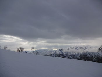 Snow covered landscape against sky