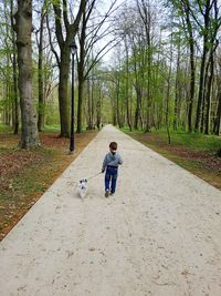 Man with dog against trees and plants